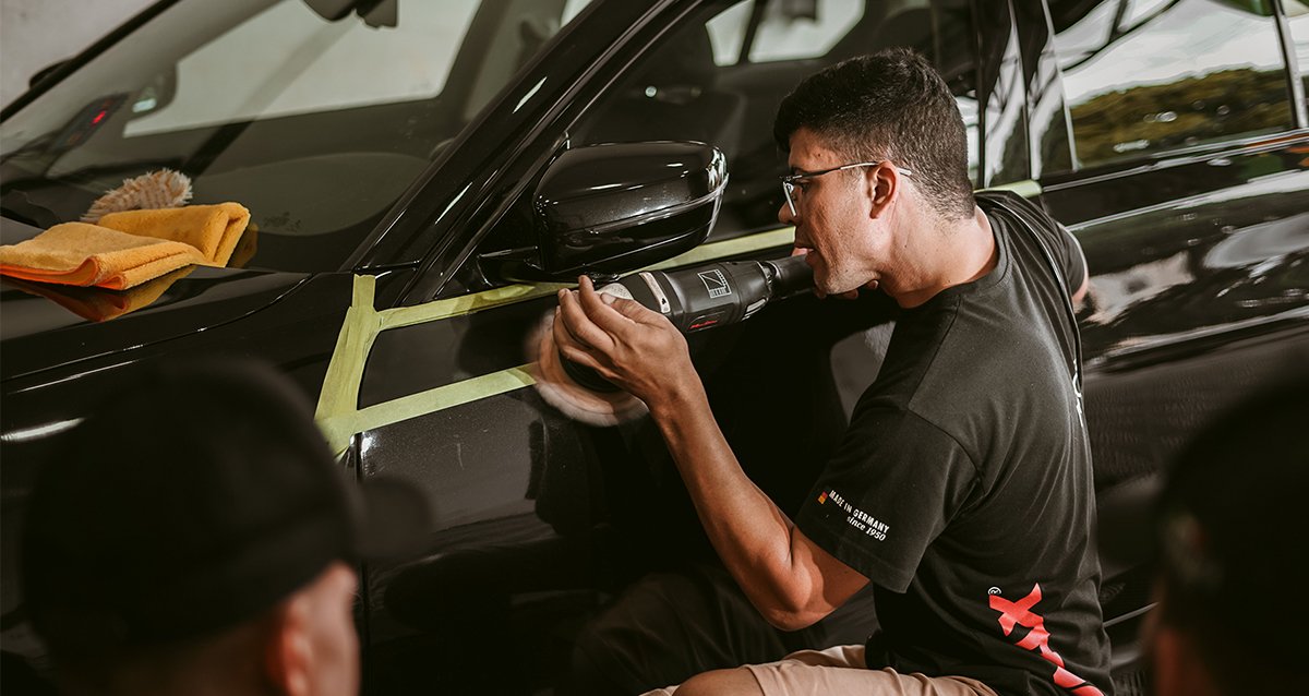 Precision detailing technique on a car in a workshop